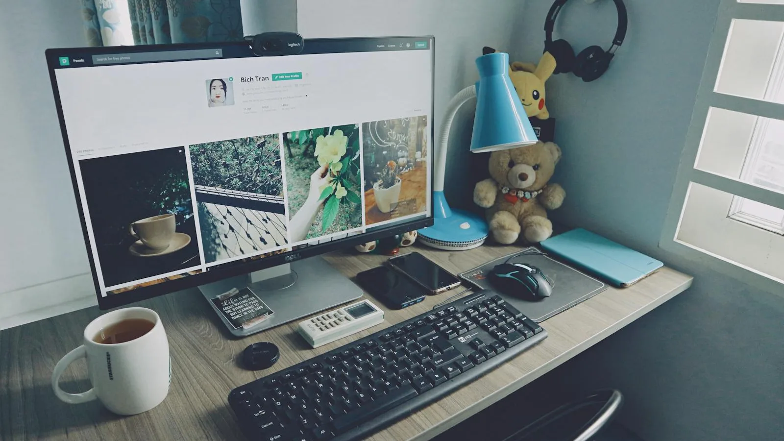 Tidy home office desk with monitor, keyboard, and a small lamp