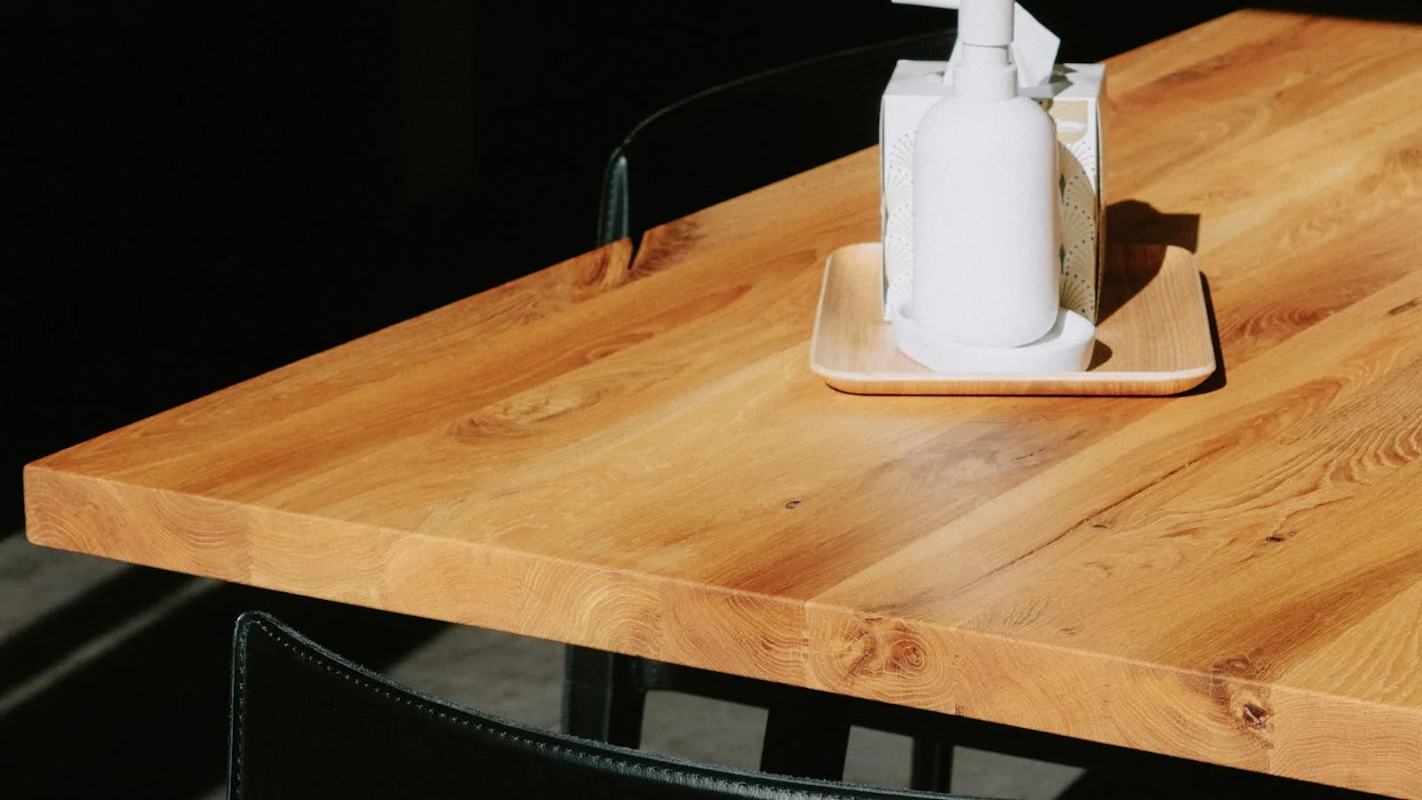Wooden plank butcher block desktop with sunlight across the grain