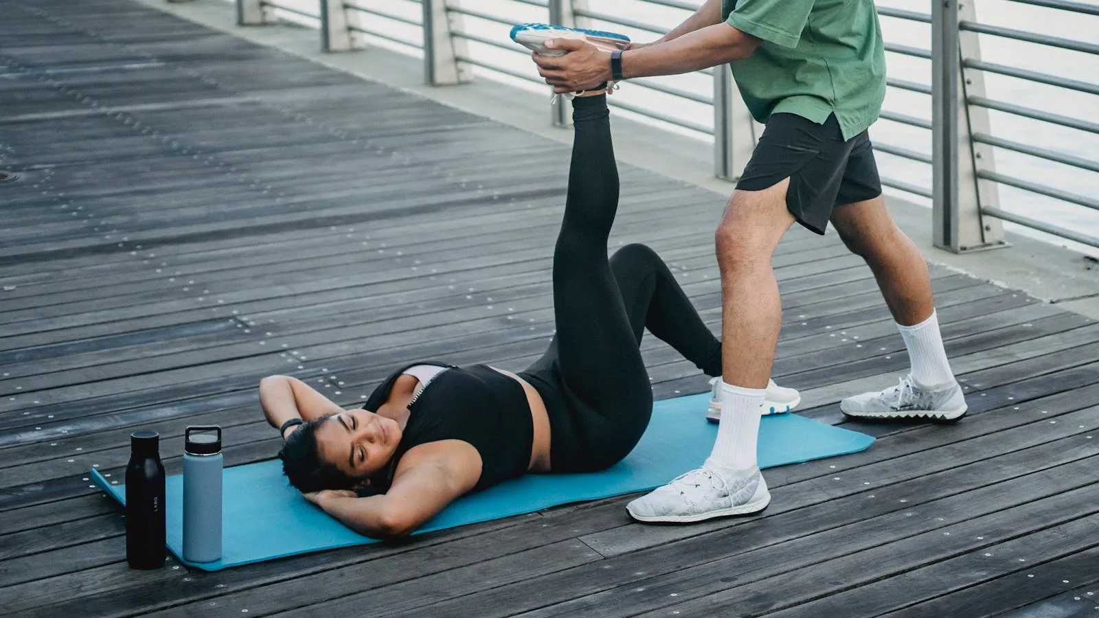 Person doing a hamstring stretch with assistance on a yoga mat