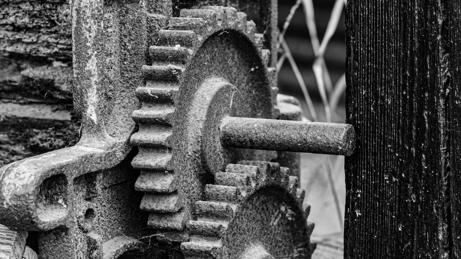 Close-up of vintage rusted gear mechanism in black and white