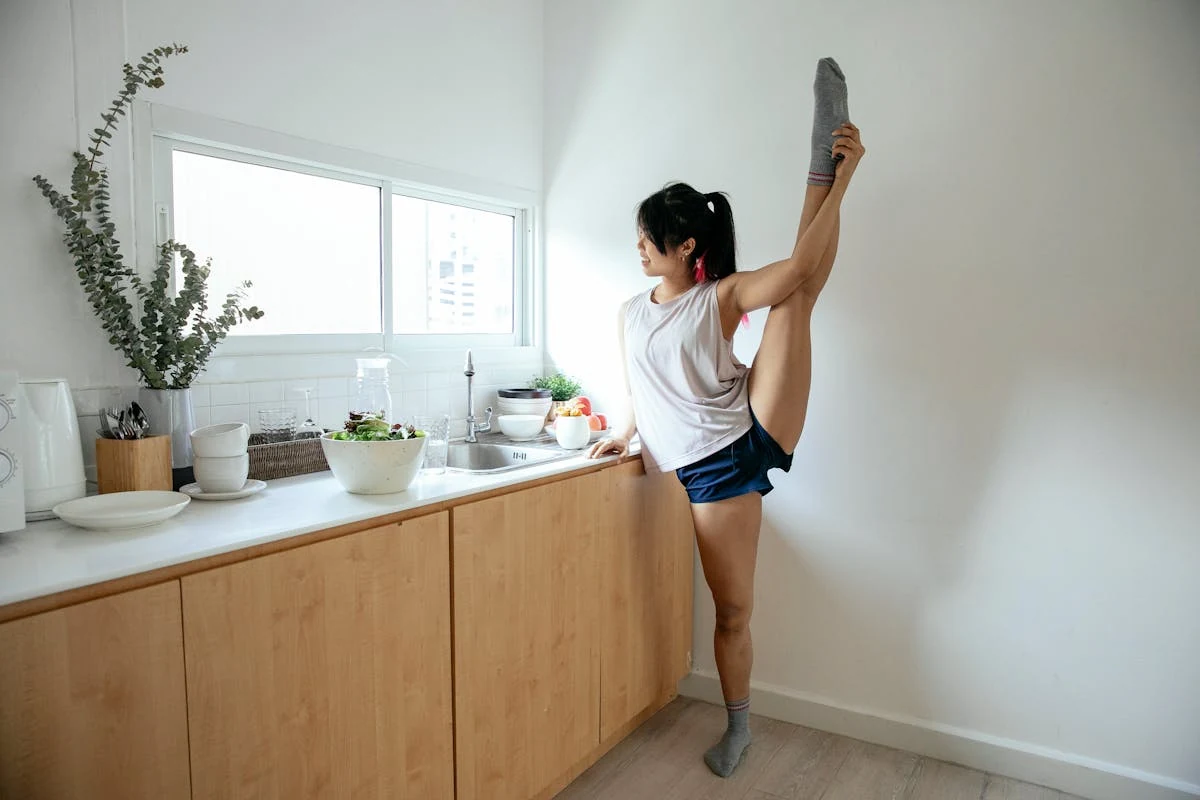 Person stretching one leg up while standing at a table