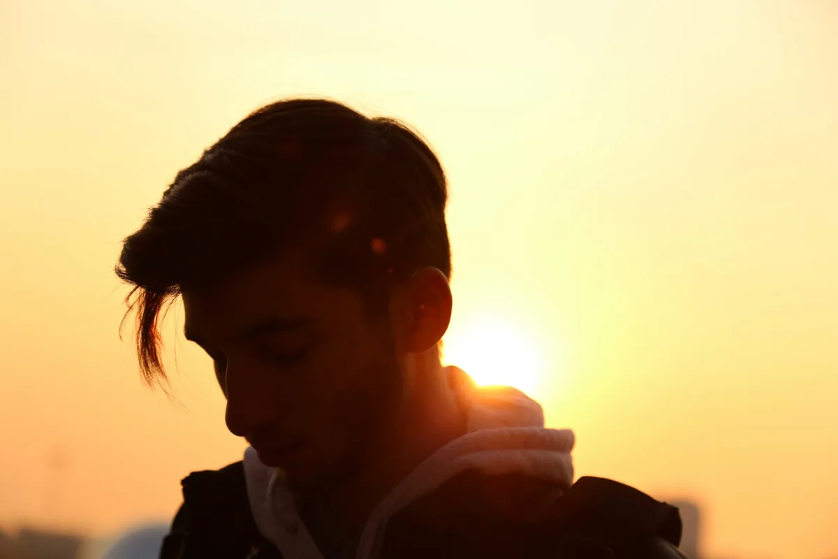 Person hunched over a phone with rounded shoulders and forward head posture